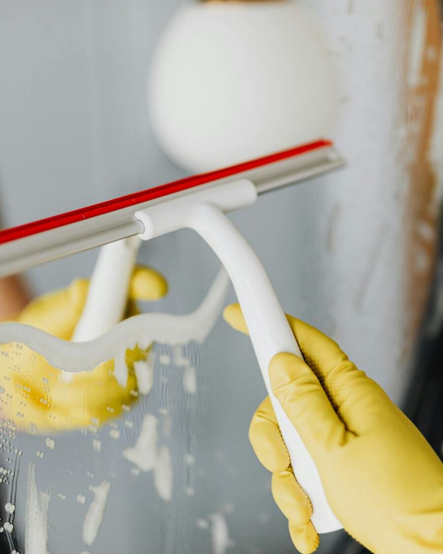 Squeegee cleaning glass shower door